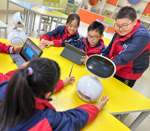 学生们手持一个“口袋乌龟然后将其放在涂有不同色彩的纸上 学生们手持一个“口袋乌龟然后将其放在涂有不同色彩的纸上